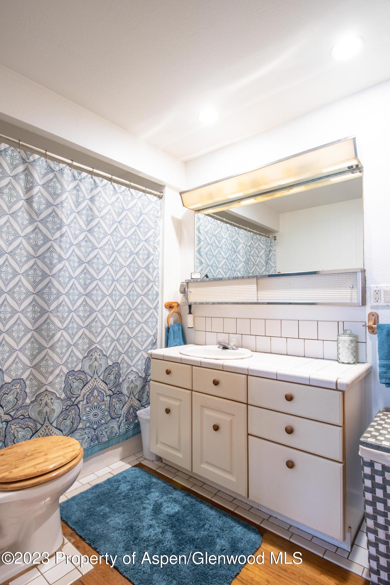 915 East 7th Street Rifle, CO 81650 - Photo 12 of 22 a bathroom with a granite countertop toilet sink and mirror