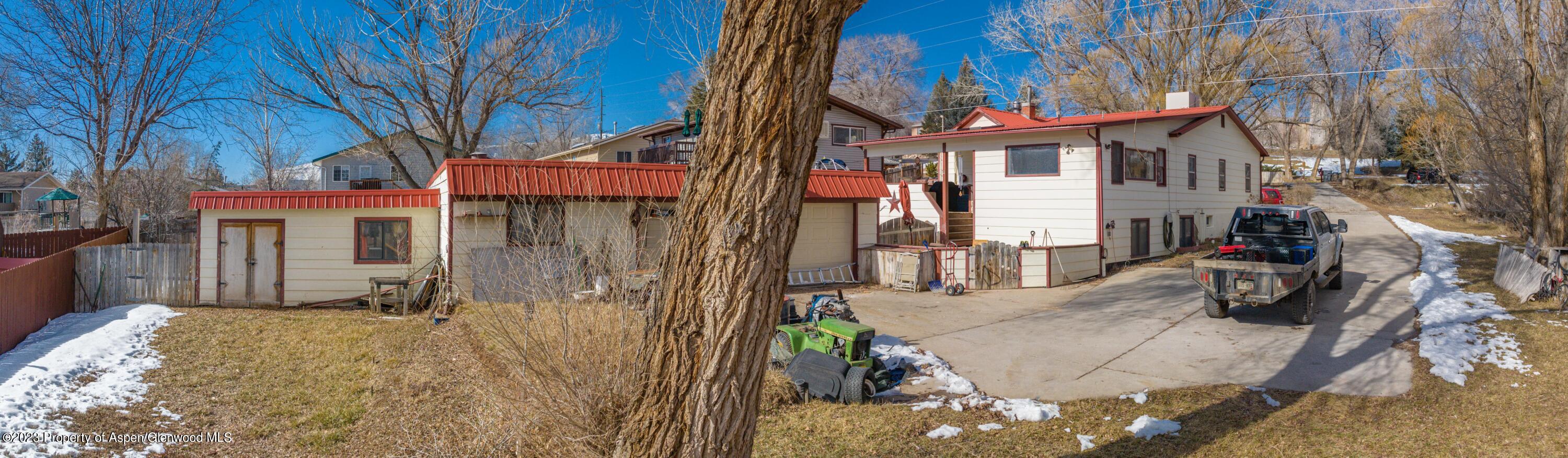 915 East 7th Street Rifle, CO 81650 - Photo 6 of 22 a view of a house with a large tree and wooden fence