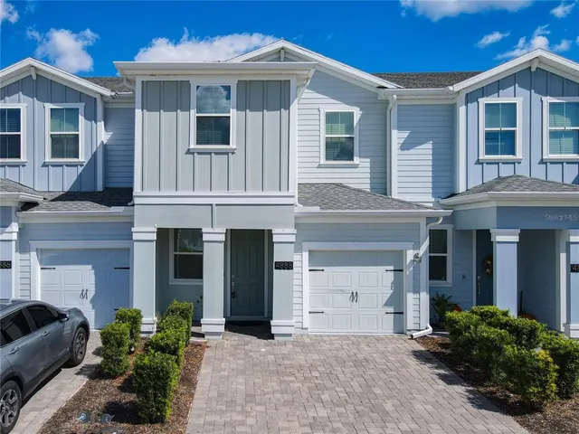 a front view of a house with yard and parking