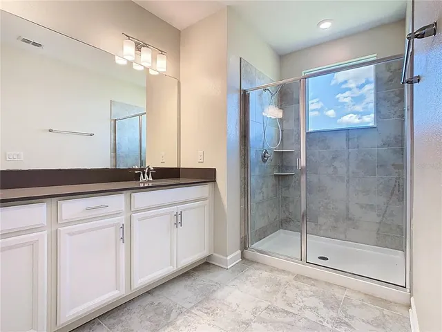 a bathroom with a shower sink and mirror