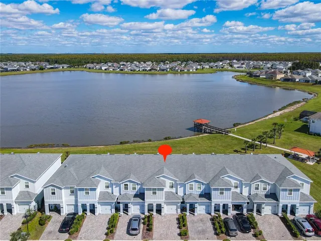 an aerial view of residential houses with outdoor space and ocean view