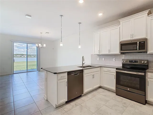 a kitchen with stainless steel appliances granite countertop a stove a sink and a microwave