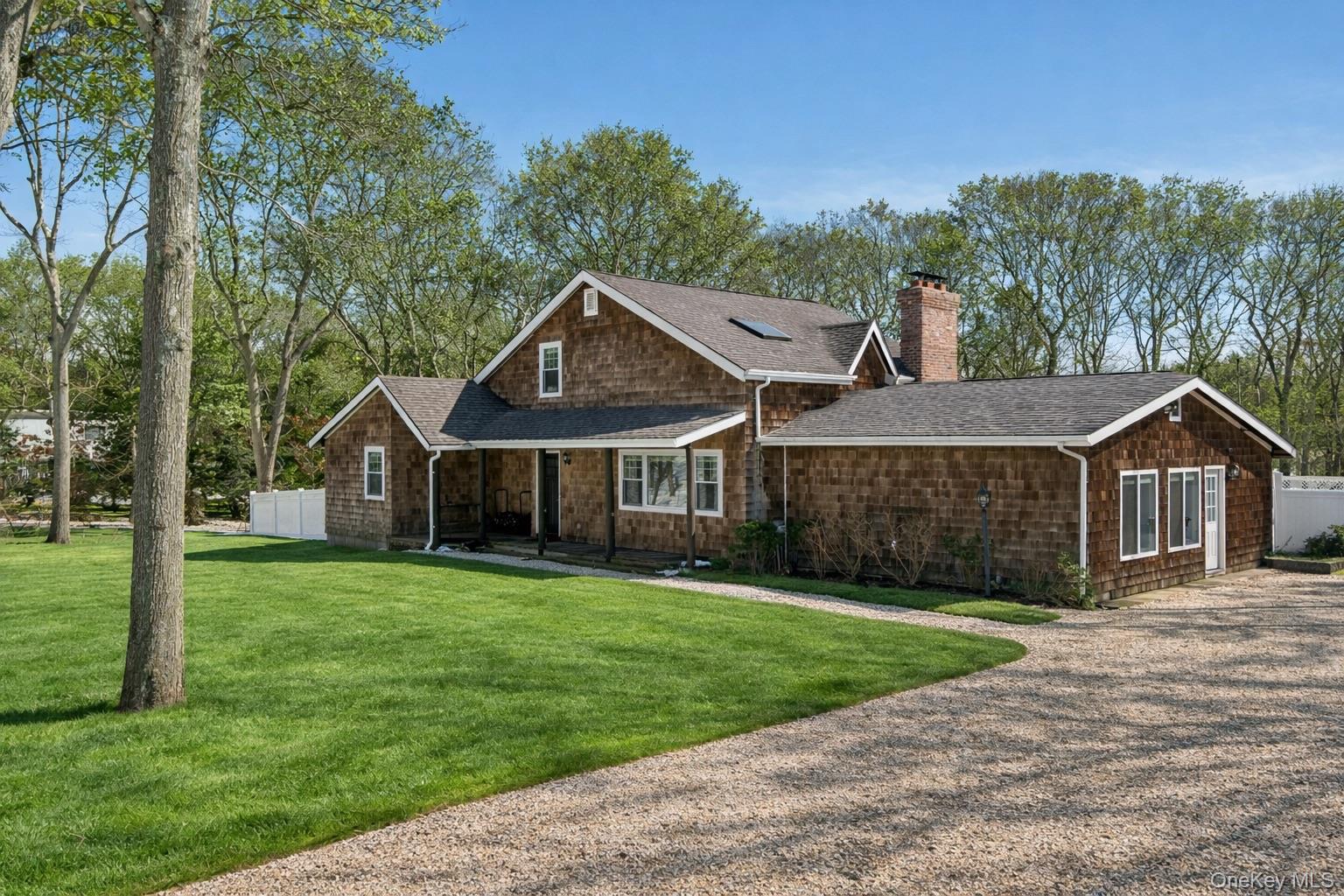4 Stuart Court Hampton Bays, NY 11946 - Photo 1 of 20 a front view of a house with yard and green space