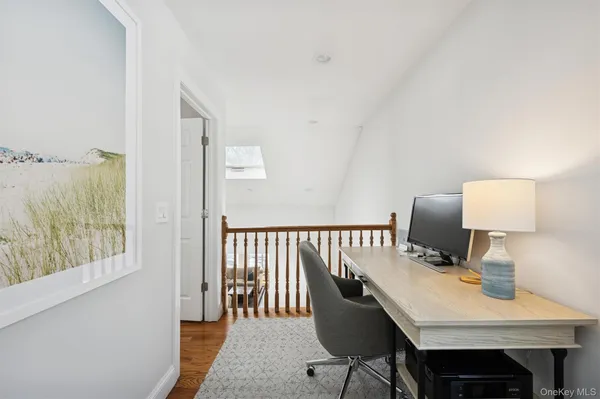 a view of a workspace with furniture and wooden floor