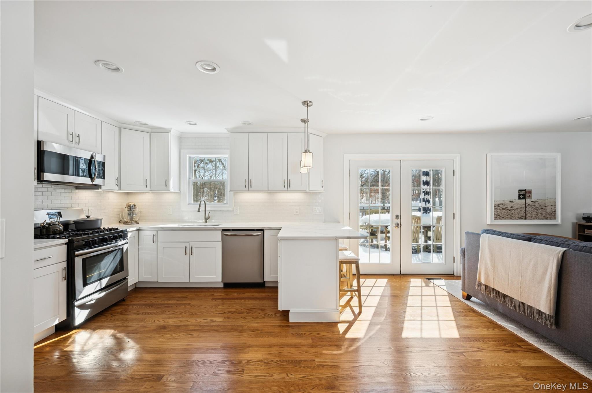 4 Stuart Court Hampton Bays, NY 11946 - Photo 2 of 20 a kitchen with granite countertop a stove top oven sink and cabinets