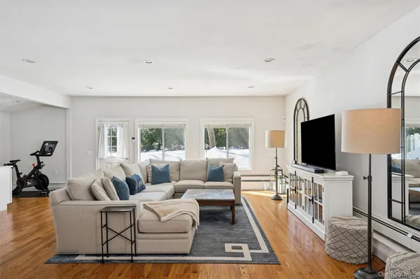 a living room with furniture wooden floor and a flat screen tv