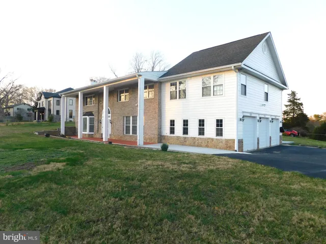 a view of a yard in front of a house with large windows