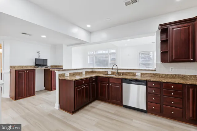 a kitchen with stainless steel appliances granite countertop wooden cabinets and a sink
