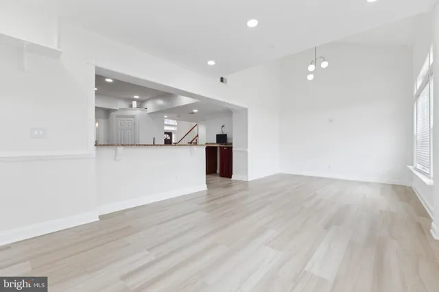 a view of a big room with wooden floor and a kitchen