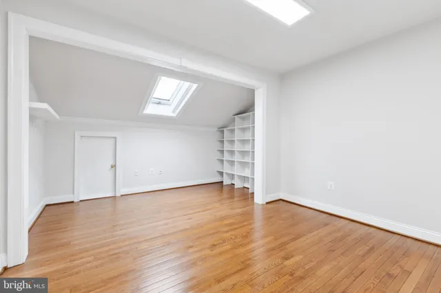 an empty room with wooden floor and window
