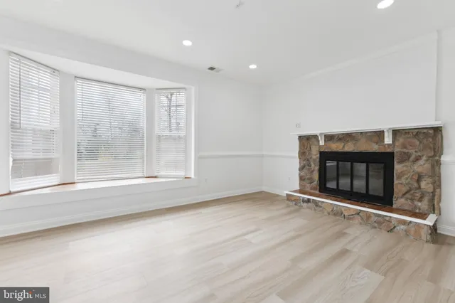 an empty room with floor to ceiling window and fireplace