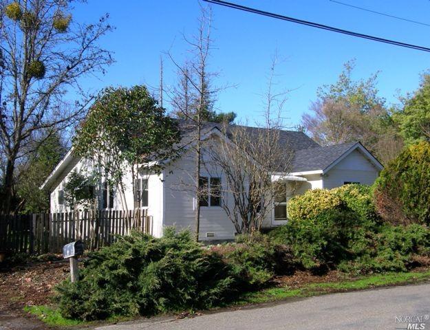 a front view of a house with plants and trees