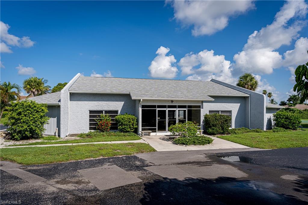 28 Watercolor Way, Unit 28 Naples, FL 34113 - Photo 27 of 29 a front view of a house with a yard and outdoor seating