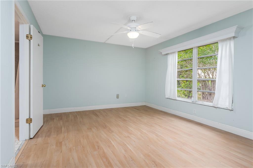 28 Watercolor Way, Unit 28 Naples, FL 34113 - Photo 8 of 29 a view of an empty room with wooden floor and a window