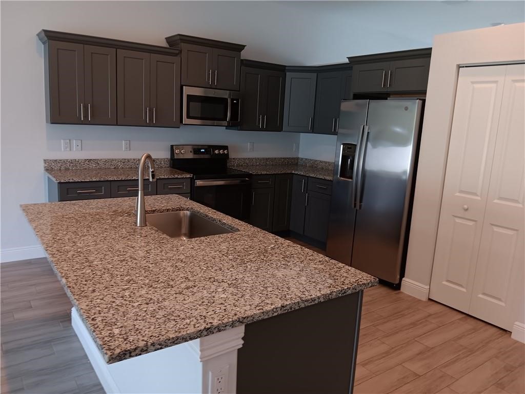 2121 Bridgehampton Terrace Vero Beach, FL 32966 - Photo 11 of 33 a kitchen with granite countertop a refrigerator and a sink