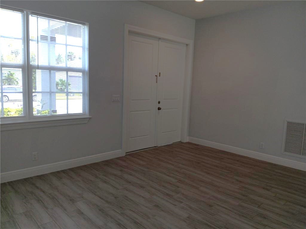 2121 Bridgehampton Terrace Vero Beach, FL 32966 - Photo 3 of 33 an empty room with wooden floor and windows