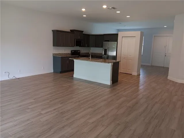 a kitchen with stainless steel appliances kitchen island wooden cabinets and granite counter tops