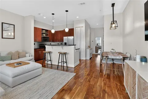 a living room with furniture a wooden floor and a sink