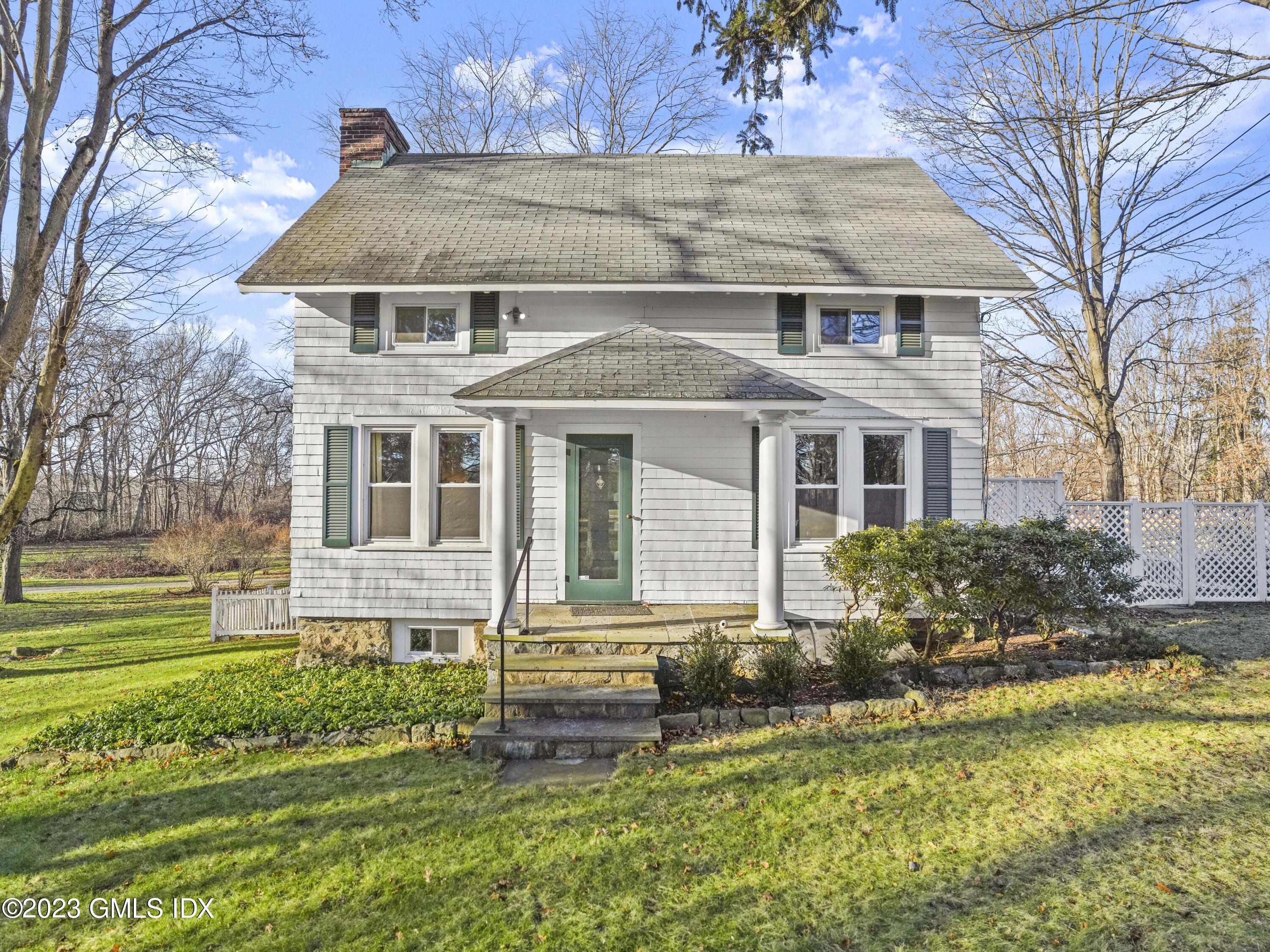 15 Locust Road, Unit COTTAGE Greenwich, CT 06831 - Photo 2 of 25 a front view of a house with a yard