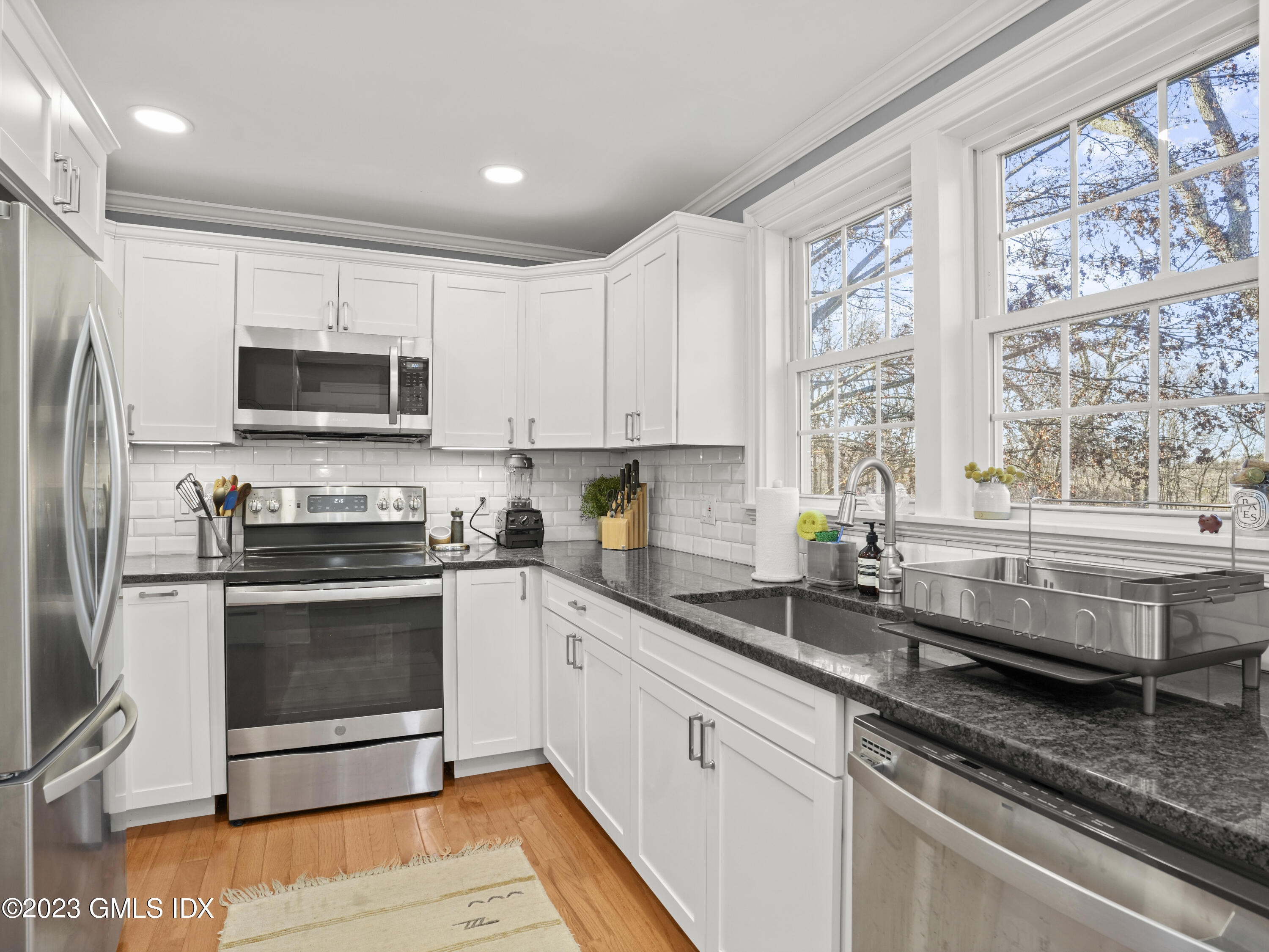 15 Locust Road, Unit COTTAGE Greenwich, CT 06831 - Photo 7 of 25 a kitchen with granite countertop a stove a sink and a microwave
