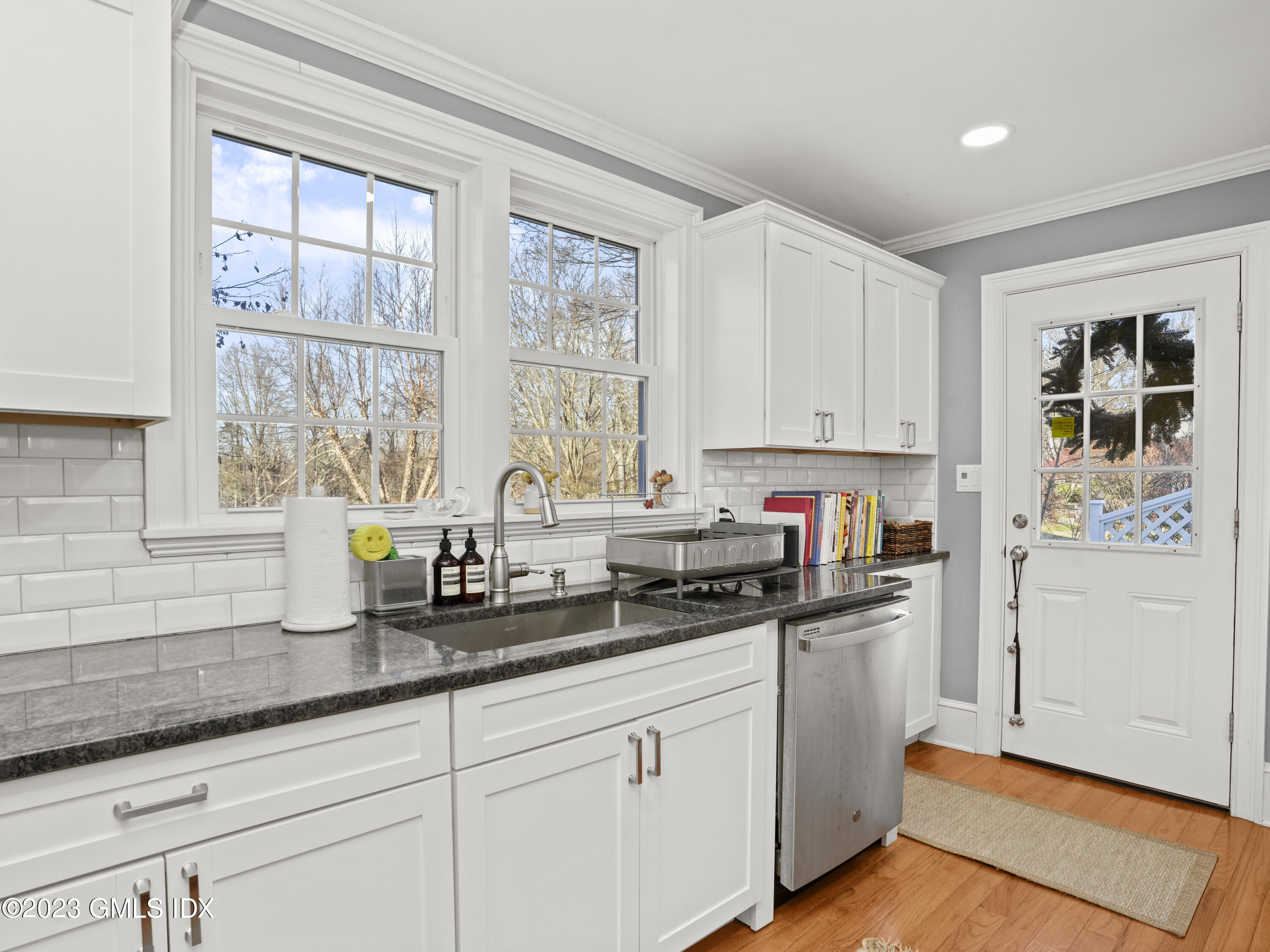 15 Locust Road, Unit COTTAGE Greenwich, CT 06831 - Photo 8 of 25 a kitchen with granite countertop white cabinets and white appliances