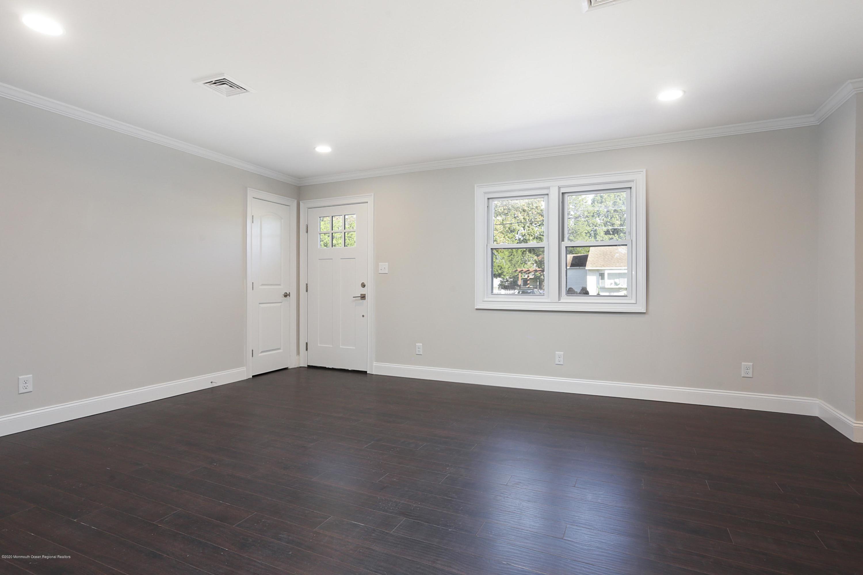 715 Pine Drive Brick, NJ 08723 - Photo 11 of 41 a view of an empty room with wooden floor and a window