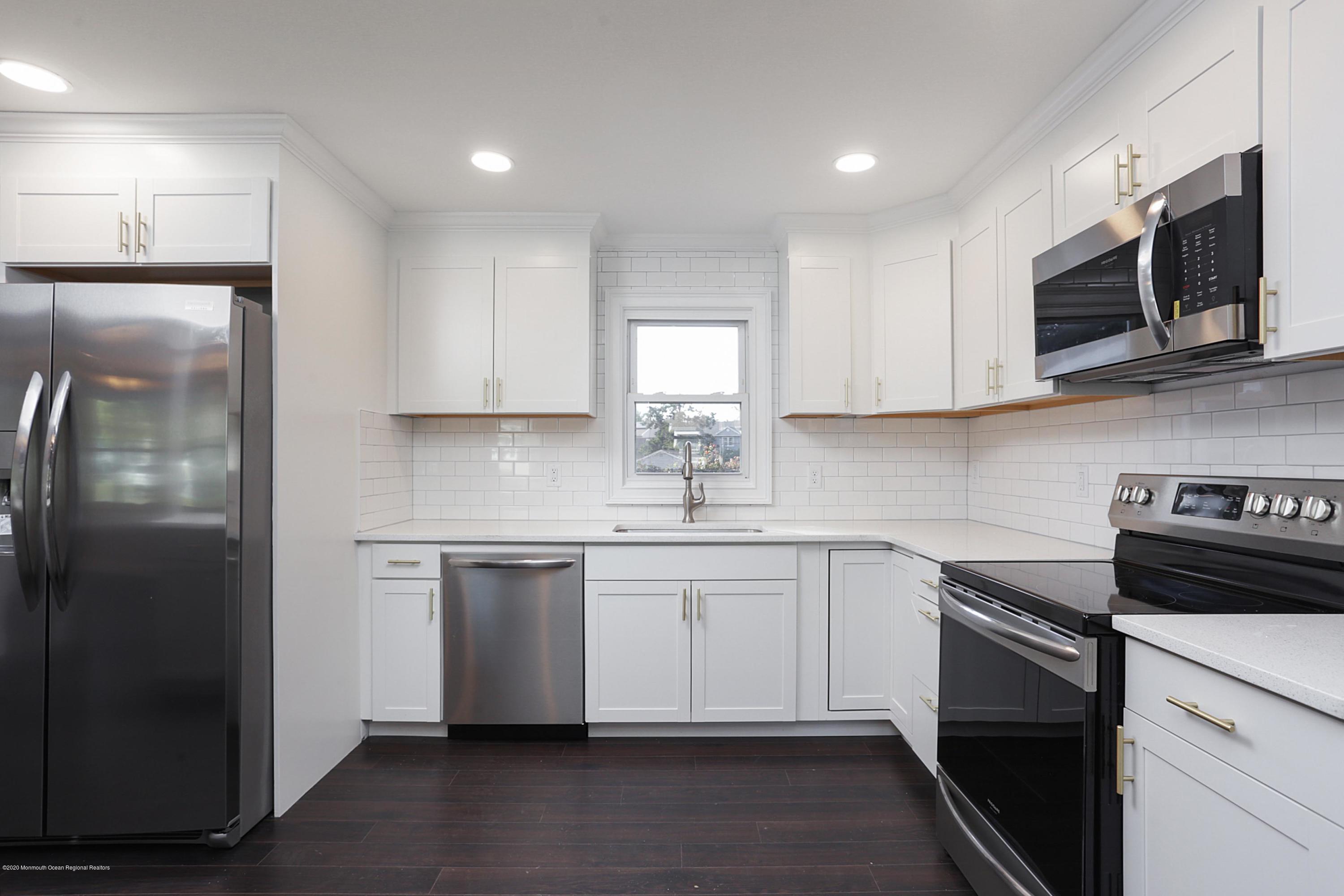 715 Pine Drive Brick, NJ 08723 - Photo 21 of 41 a kitchen with stainless steel appliances granite countertop a stove a sink and a microwave
