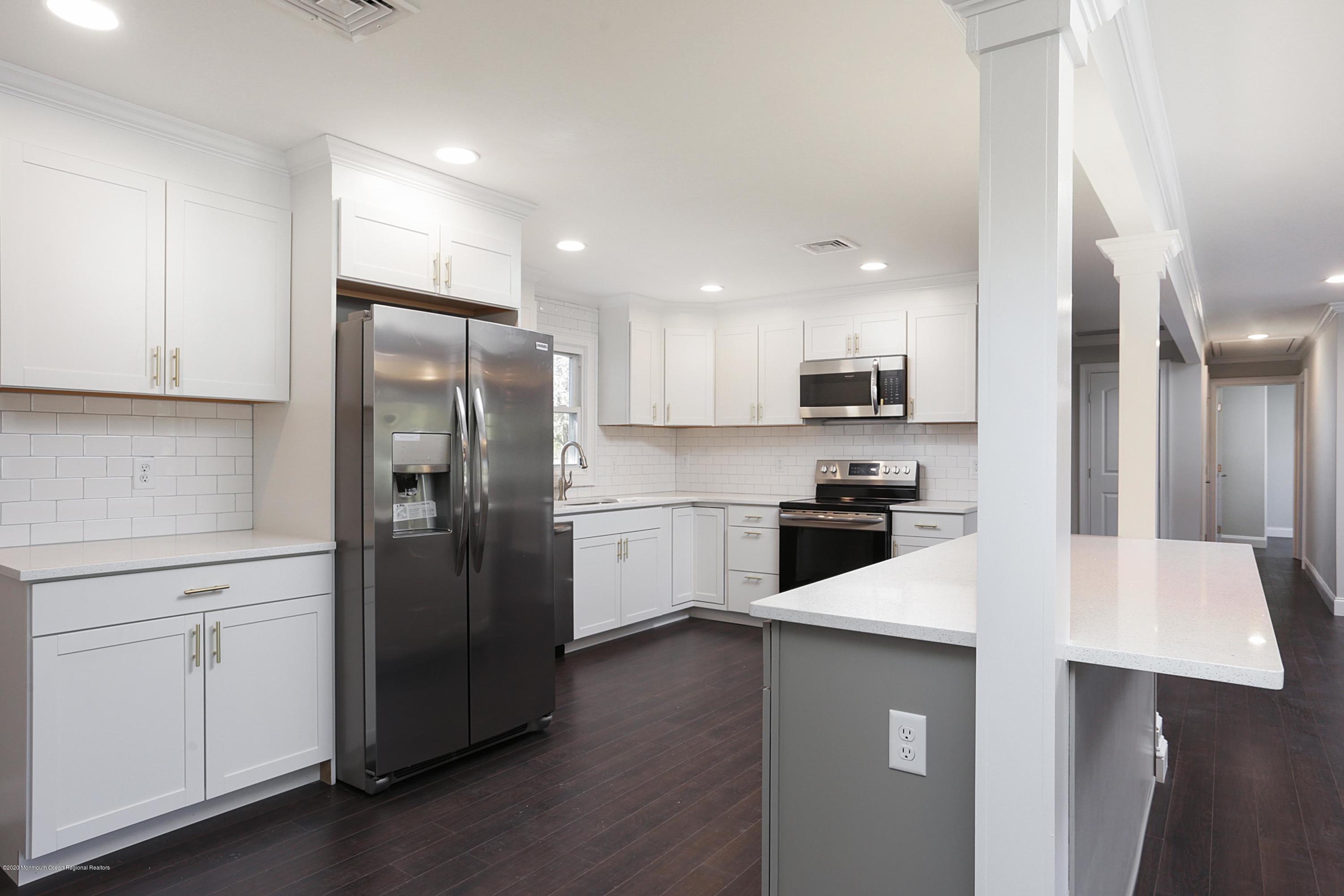 715 Pine Drive Brick, NJ 08723 - Photo 22 of 41 a kitchen with stainless steel appliances a refrigerator sink and cabinets