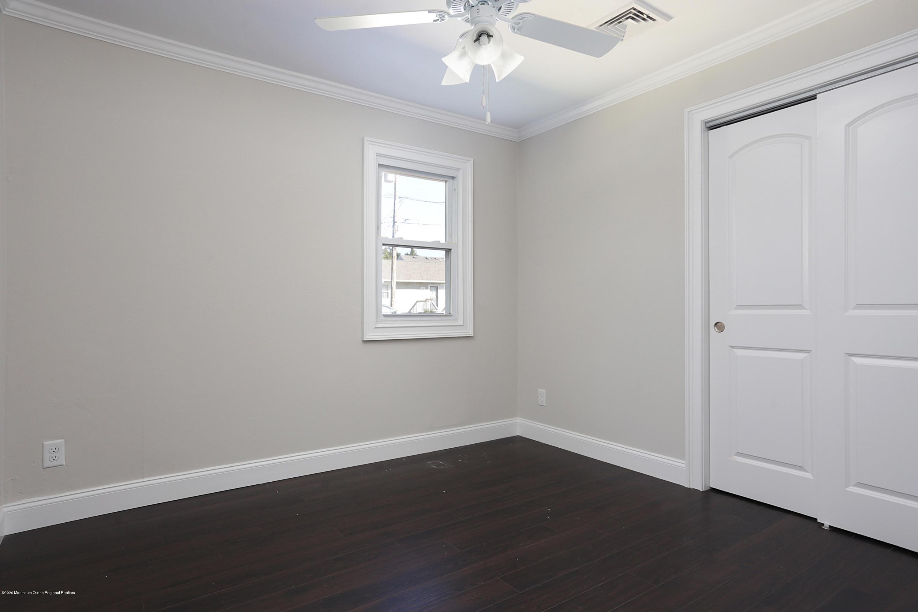 715 Pine Drive Brick, NJ 08723 - Photo 29 of 41 an empty room with wooden floor and windows