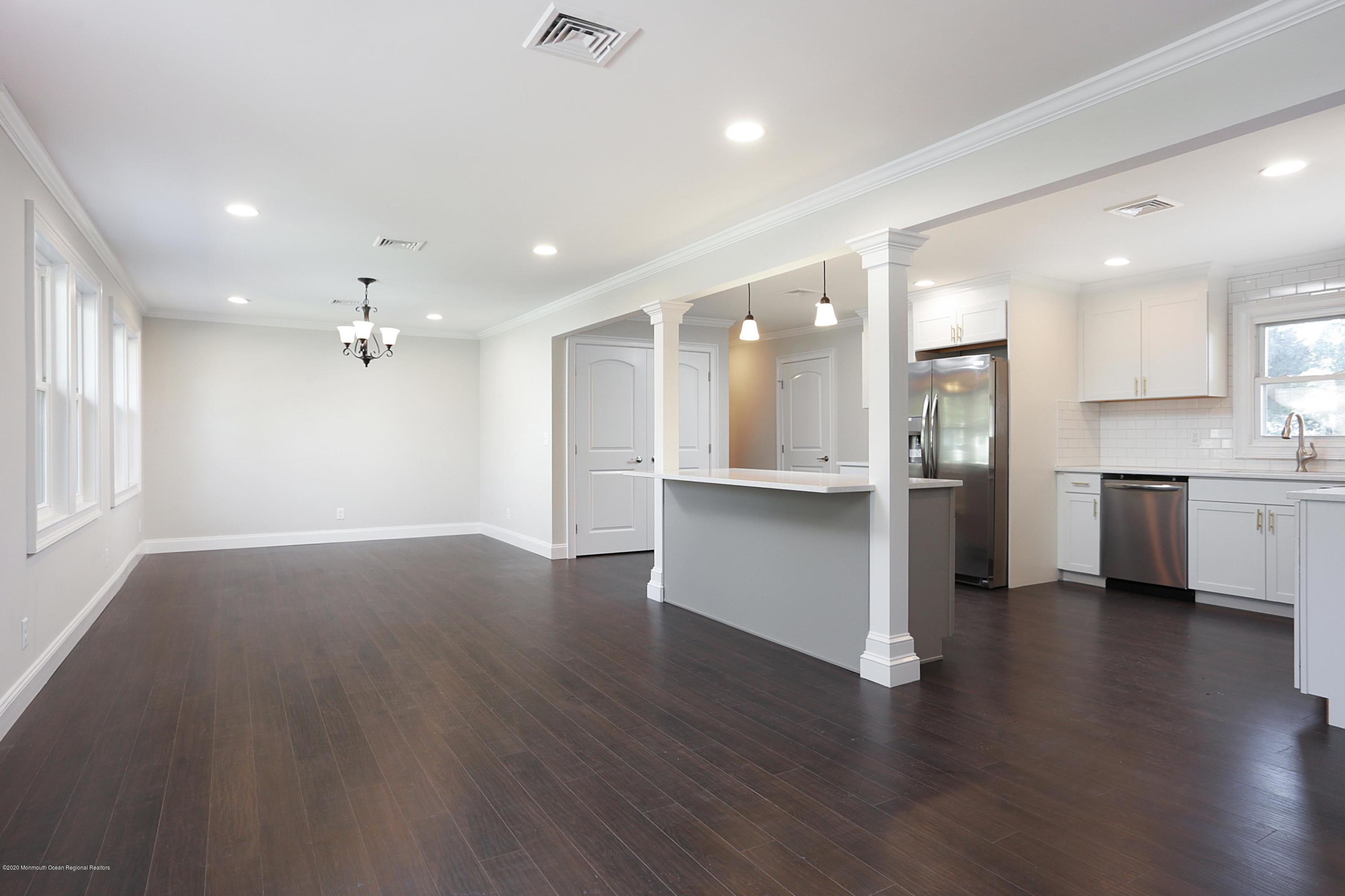 715 Pine Drive Brick, NJ 08723 - Photo 7 of 41 a view of an empty room and kitchen with wooden floor