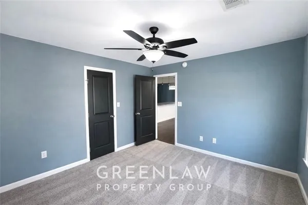 a view of a big room with closet and a ceiling fan