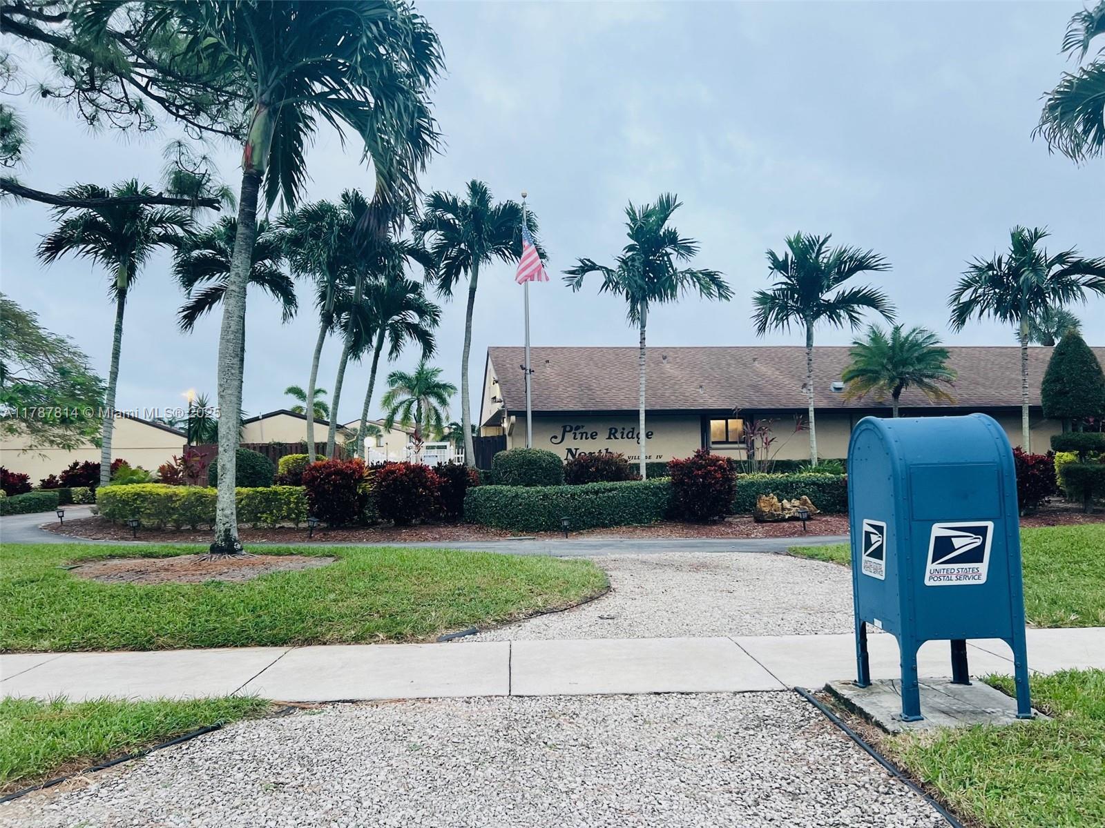 819 Sky Pine Way, Unit D3 Greenacres, FL 33415 - Photo 11 of 11 a front view of a house with garden and trees