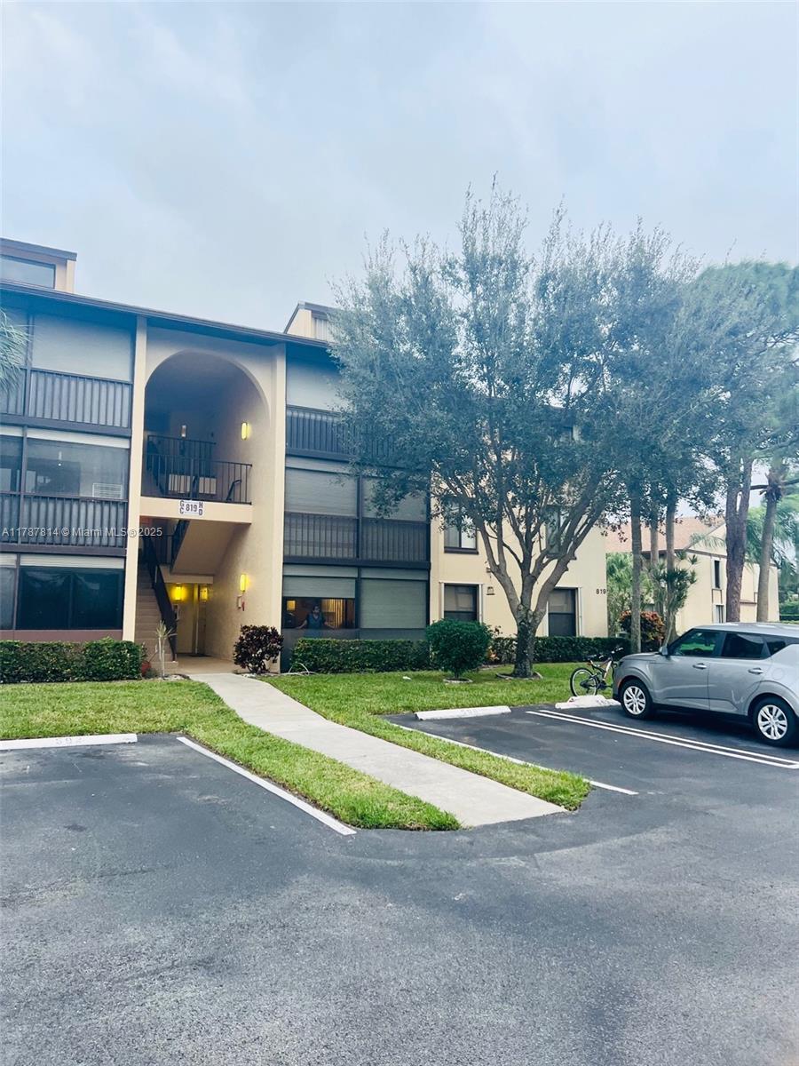 819 Sky Pine Way, Unit D3 Greenacres, FL 33415 - Photo 8 of 11 a view of a parked cars in front of a building