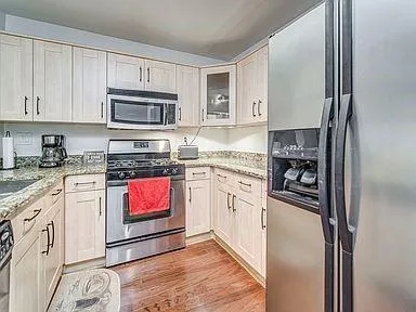 a kitchen with stainless steel appliances granite countertop a refrigerator sink and stove