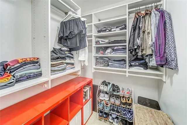a view of walk in closet with clothes and shoes