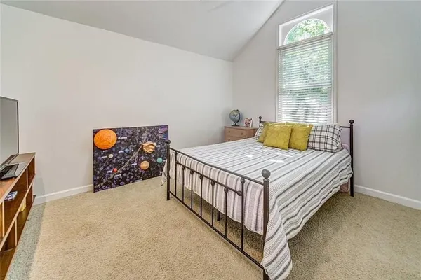 a bed sitting in a bedroom next to a window