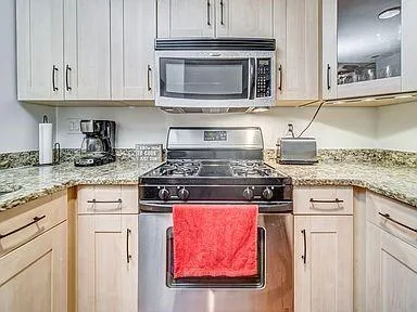 a kitchen with granite countertop cabinets stainless steel appliances and a sink