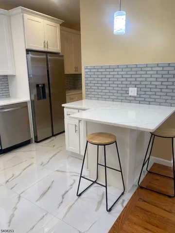 a kitchen with a sink a refrigerator and cabinets