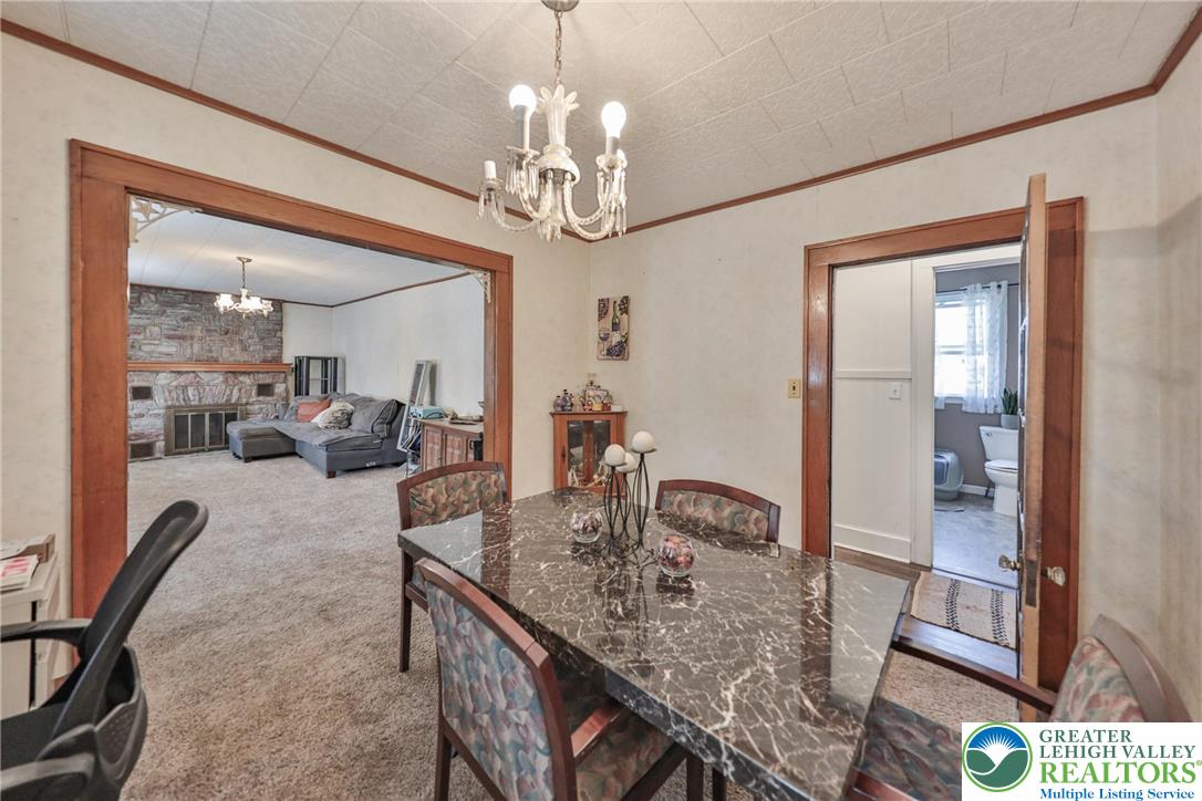 417 3rd Street Lehighton, PA 18235 - Photo 18 of 39 This formal dining space offers warm wood trim, a decorative chandelier, and an adjoining living area with a natural stone fireplace.