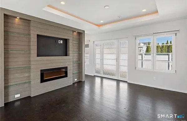 an empty room with windows and fireplace