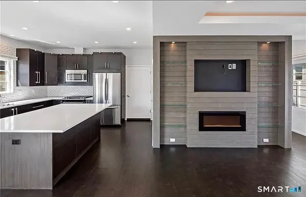 a large kitchen with stainless steel appliances a large counter top stove and a refrigerator