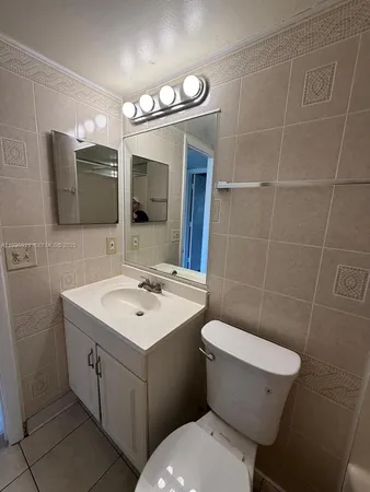 a bathroom with a toilet sink and mirror