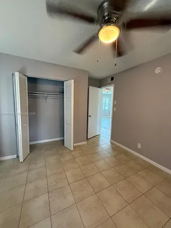 a view of an empty room with a window and cabinet
