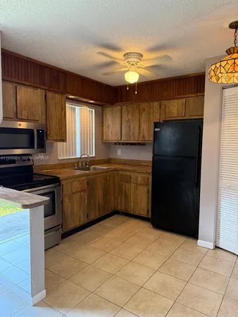 a kitchen with stainless steel appliances a refrigerator a sink a stove and cabinets