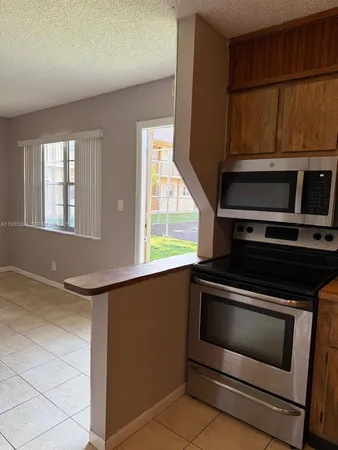 a kitchen with wooden cabinets and a stove top oven