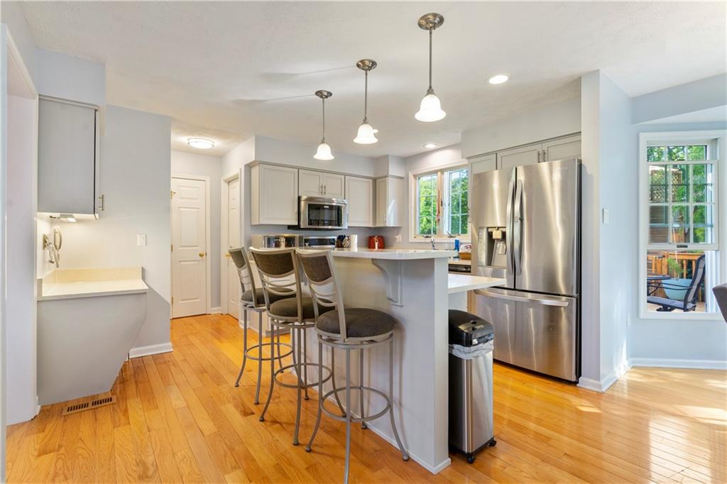 104 Field Club Circle McKees Rocks, PA 15136 - Photo 5 of 25 a kitchen with stainless steel appliances a dining table chairs refrigerator and microwave