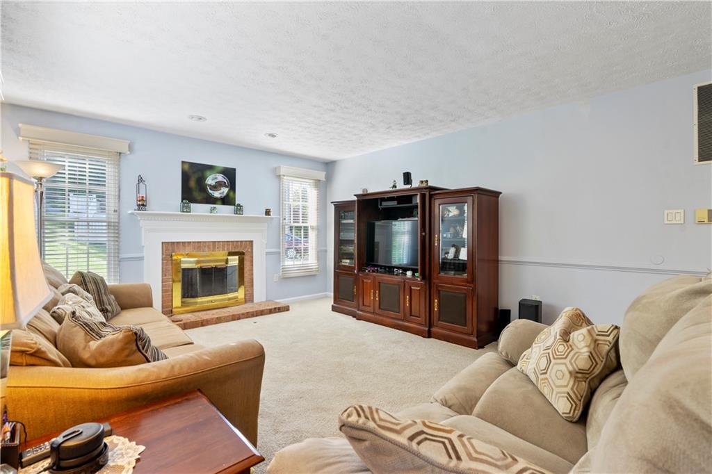 104 Field Club Circle McKees Rocks, PA 15136 - Photo 6 of 25 a living room with furniture a flat screen tv and a fireplace