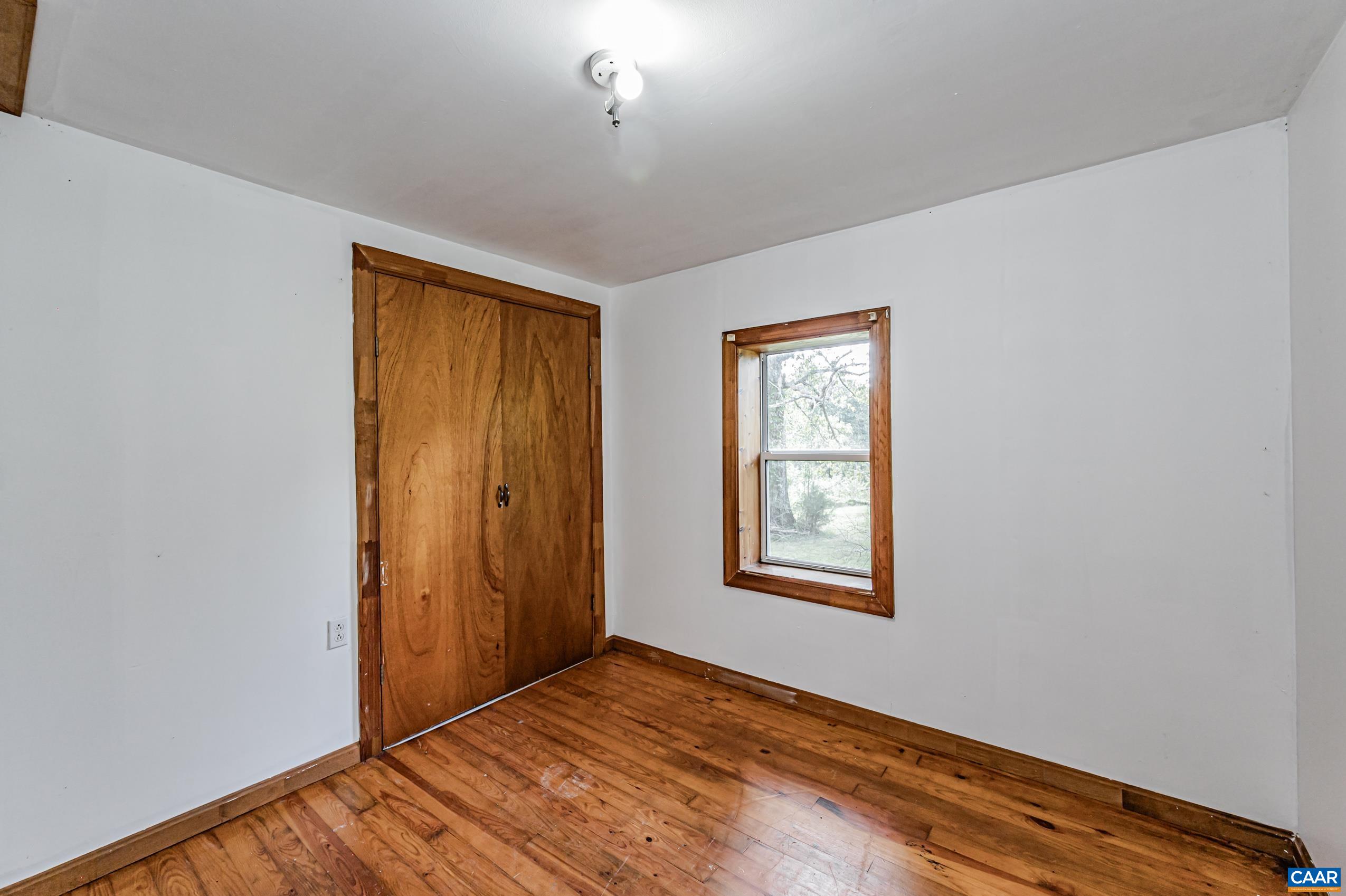 431 Graves Mill Road Madison, VA 22727 - Photo 14 of 26 a view of an empty room with window and wooden floor