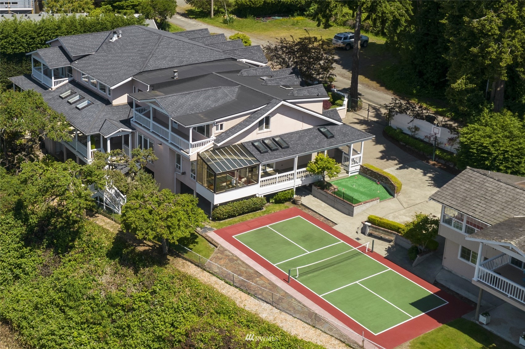 an aerial view of a tennis ground with a white house