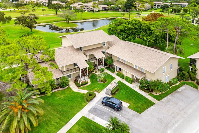 an aerial view of a house with an outdoor space and seating area